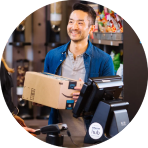 A man holding a box while standing at a cash register