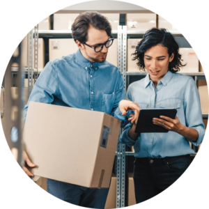 A man holding a box standing next to a woman holding a tablet