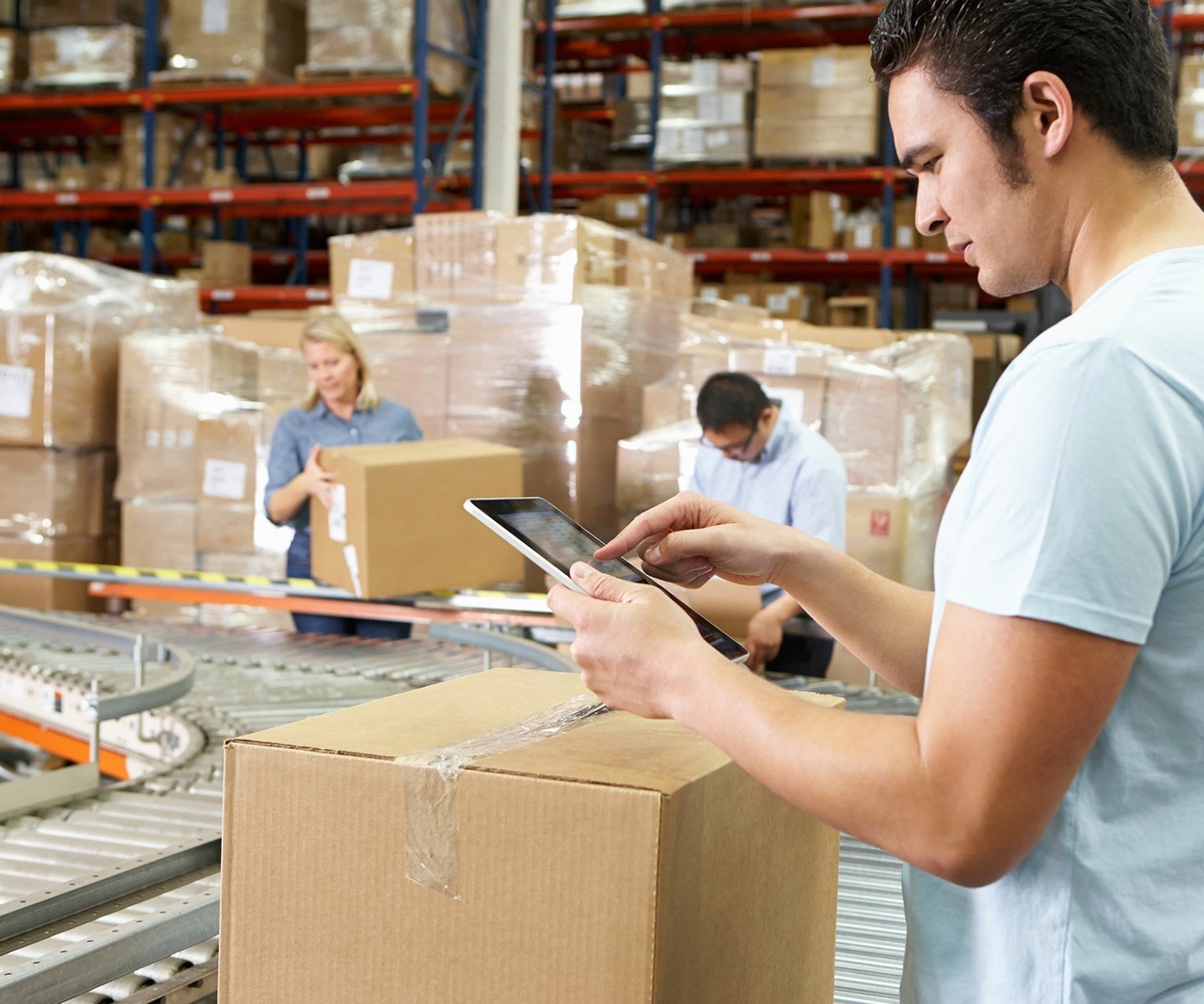 Workers in a warehouse with boxes on a conveyor belt