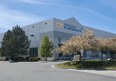 The Relentless Fulfillment facility shown from outside, surrounded by trees.