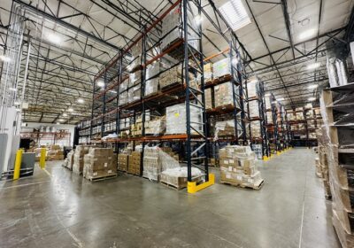 A large warehouse filled with many cardboard boxes on shelves.