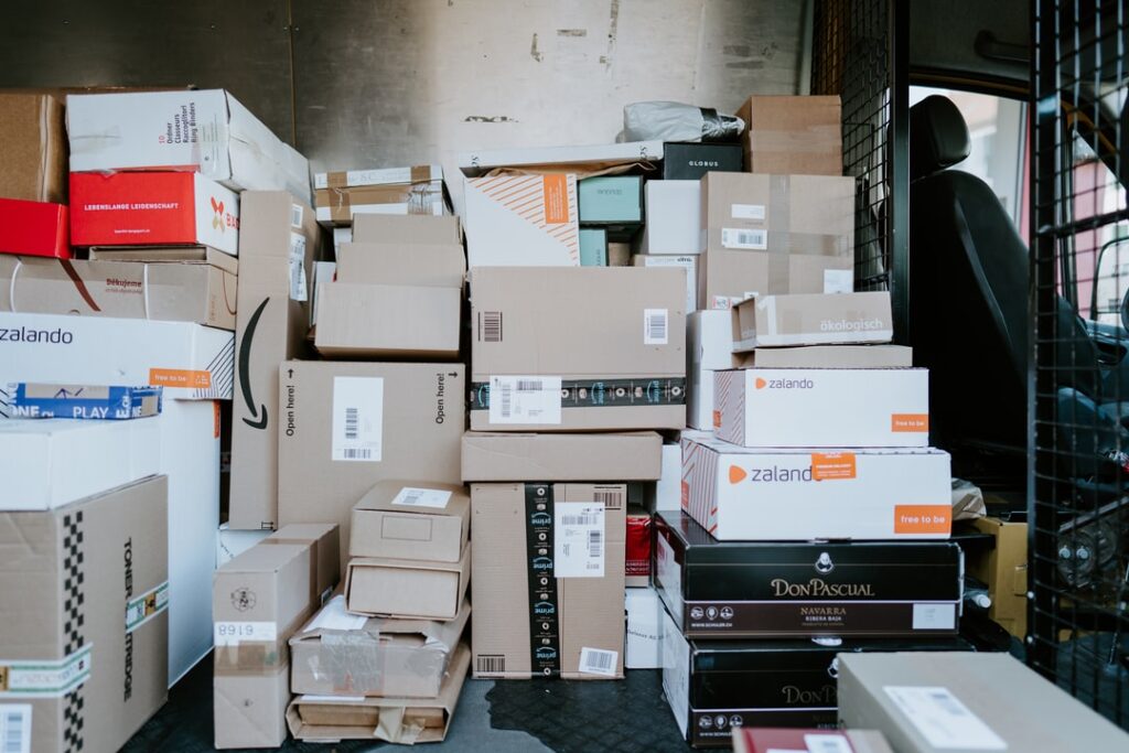 Many boxes and packages in the back of a delivery truck.
