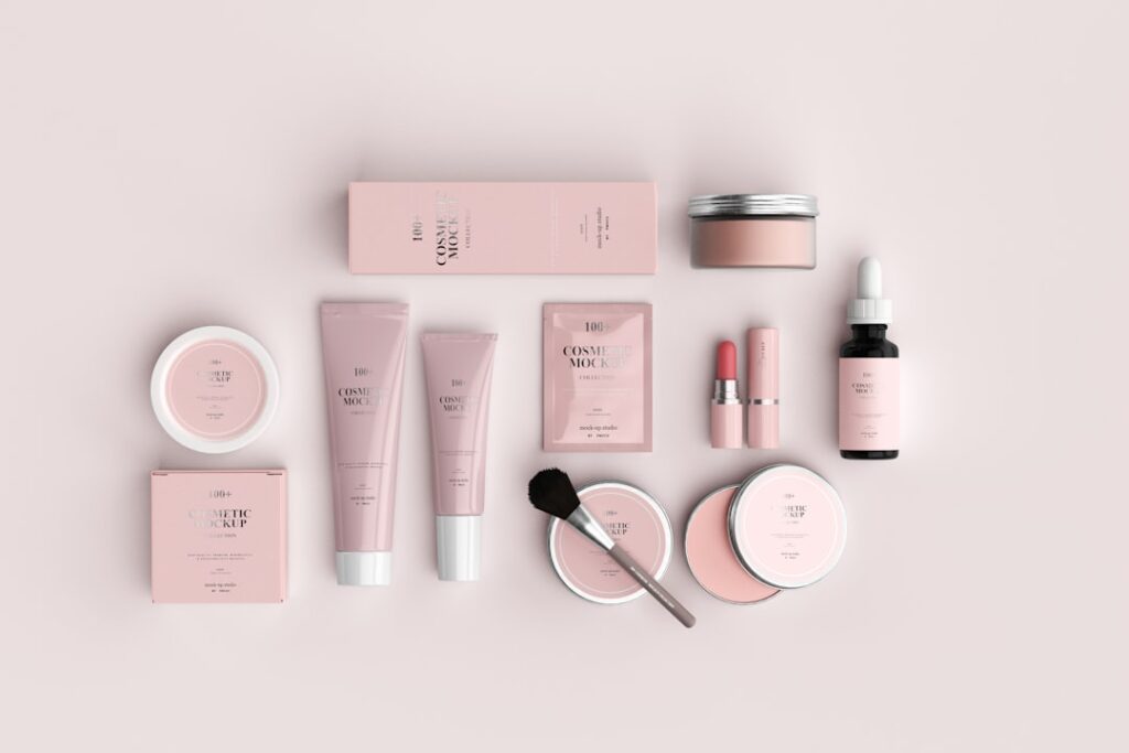 Various cosmetics and beauty products in light pink packaging, against a matching pink background.