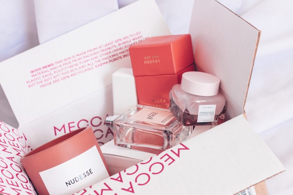 A box full of beauty and cosmetics products in shades of pink and red.